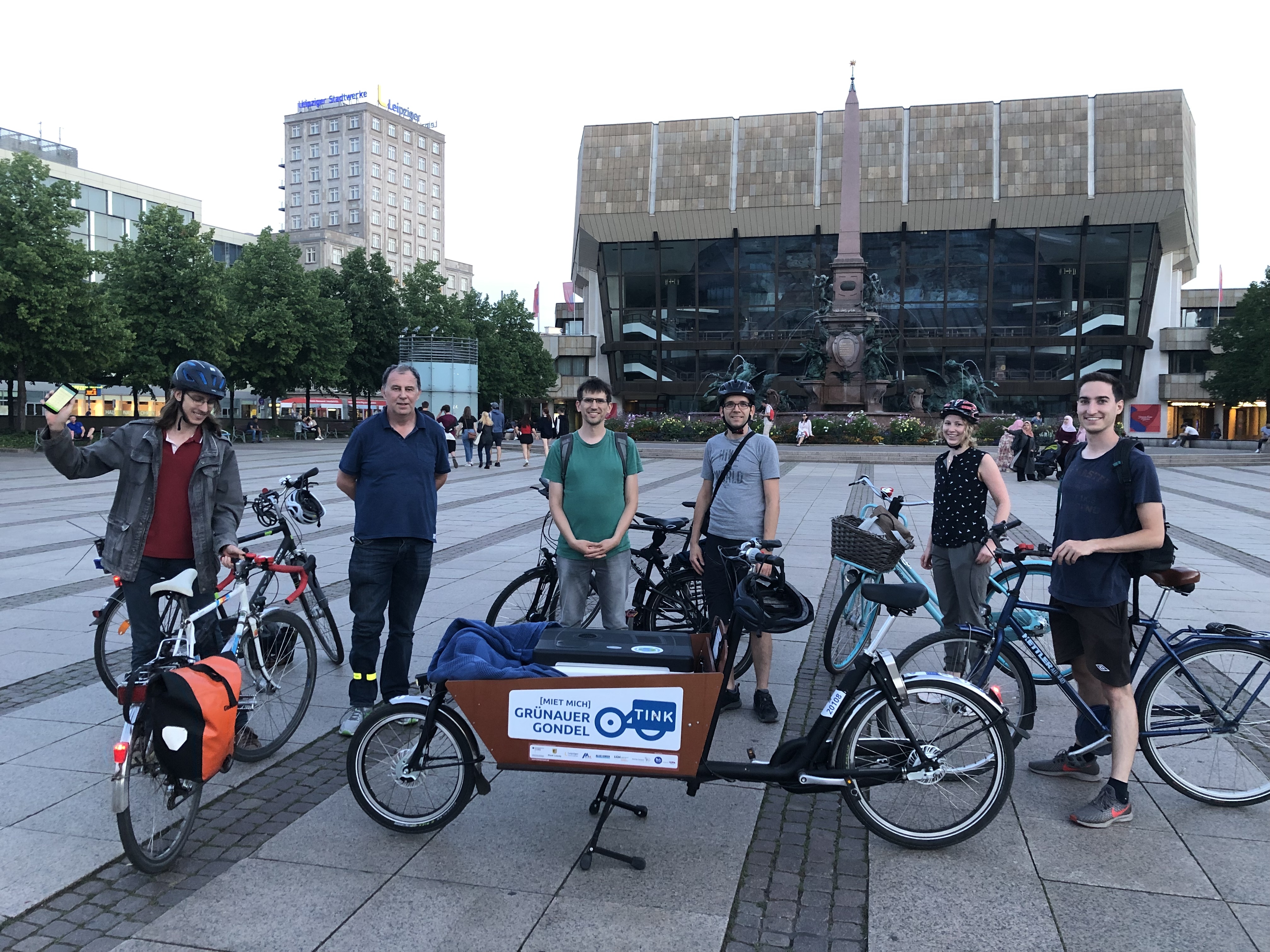 Gruppe von Fahrradfahrenden auf dem Augustusplatz in einem Halbkreis um ein Lastenrad positioniert.